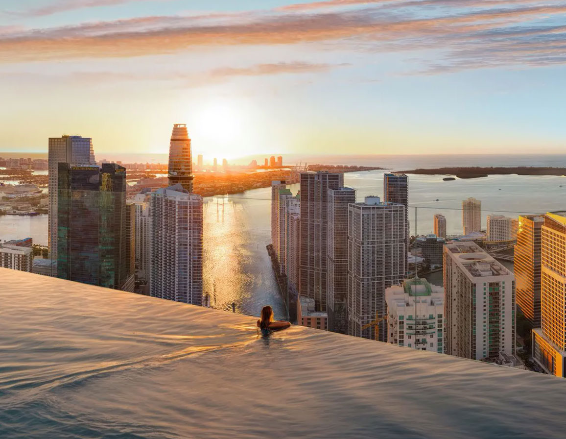 Faena Residences infinity pool with panoramic view of Miami at sunset, highlighting the luxury of apartments for sale.