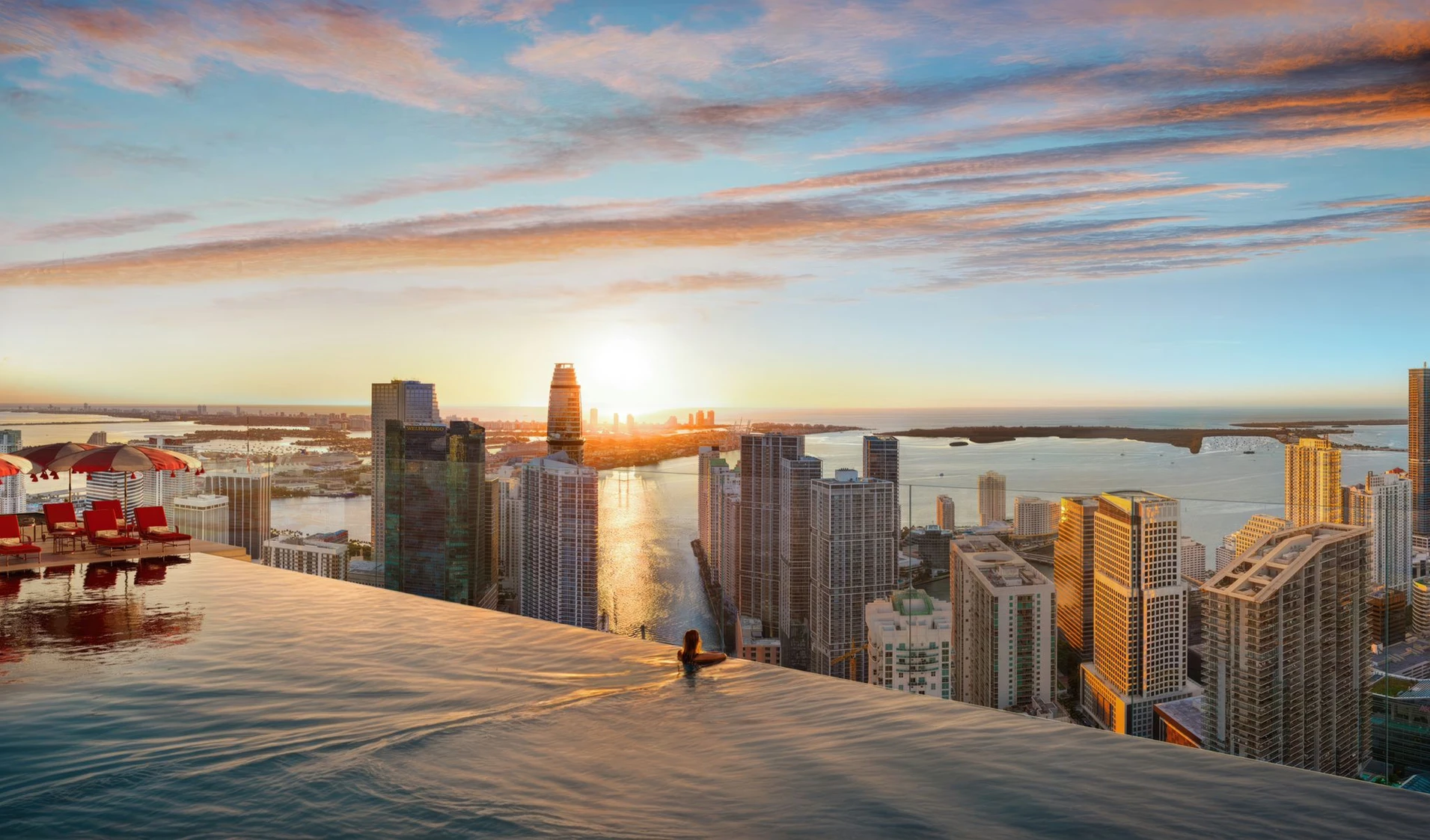 Faena Residences infinity pool with panoramic view of Miami at sunset, highlighting the luxury of apartments for sale.